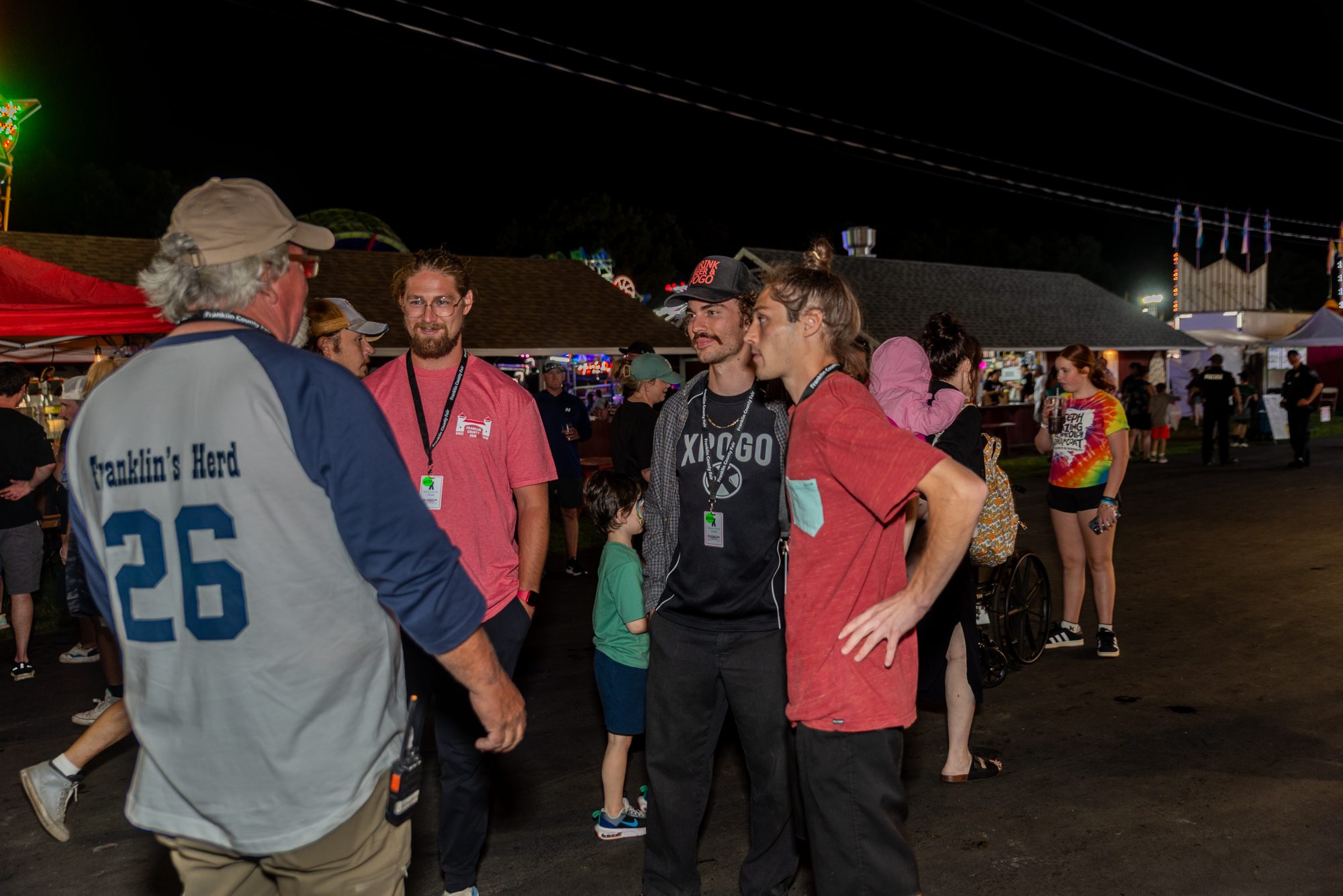 Steve DeJoy talking with crew members on the midway at night
